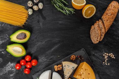 Farklı yiyeceklerle siyah masa, doğal tarım ürünleri, üst görünüm, metin için çerçeve