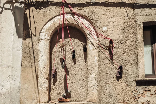 SAN FILI / ITALY -  AUGUST 2019: hanging shoes in the old town — Stock Photo, Image