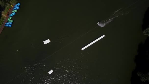 Tiro aéreo de um teleférico em um lago com um wakeboarder — Vídeo de Stock