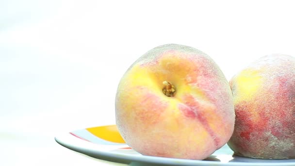 Персики вращаются на тарелке . — стоковое видео