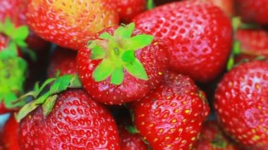 Olgun çilek beyaz bir arka plan üzerinde döner. Meyve parlak ışık arka plan üzerinde yavaş döndürme