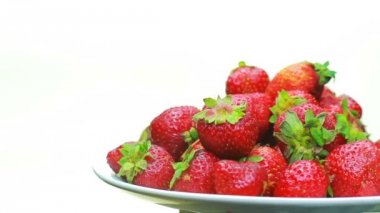 Olgun çilek beyaz bir arka plan üzerinde döner.