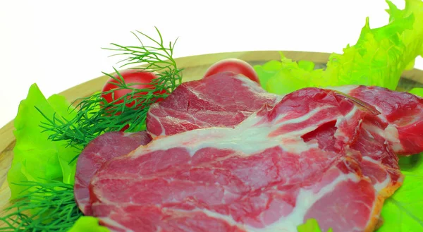 Ahşap bir gemide sebze ile Füme pastırma mı. Domates, salatalık, salata, dilimlenmiş jambon beyaz bir arka plan üzerinde ahşap bir gemide iştah açıcı
