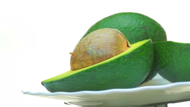 Ready-to jíst avokádo. . Na bílém pozadí leží ovoce avokádo jako pozadí. — Stock video