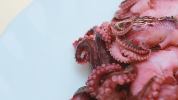 Gemarineerde octopus op een plaat. Een heleboel octopus op een witte achtergrond, 3-5 cm in lengte — Stockvideo