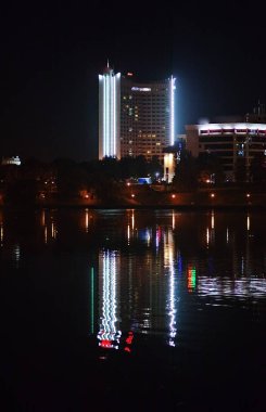 Gece şehir nehrin yanında. Güzel görünüm için arka plan, Beyaz Rusya, Minsk, Nemiga Caddesi metropol.