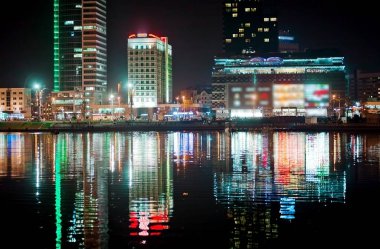 Gece şehir nehrin yanında. Güzel görünüm için arka plan, Beyaz Rusya, Minsk, Nemiga Caddesi metropol.