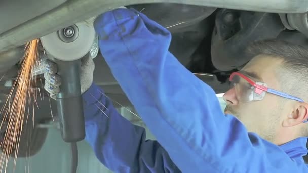 Mechanic cuts off the muffler in the car. — Stock Video