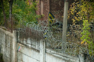 paslı dikenli tel çit zemin terk edilmiş bir binada ve mavi gökyüzü karşı