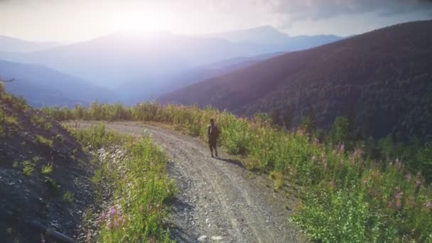 Gün batımı dağ yolda yürürken adam Traveler — Stok video