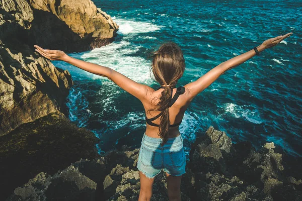 Chica joven con los brazos levantados. Isla de Nusa Penida —  Fotos de Stock