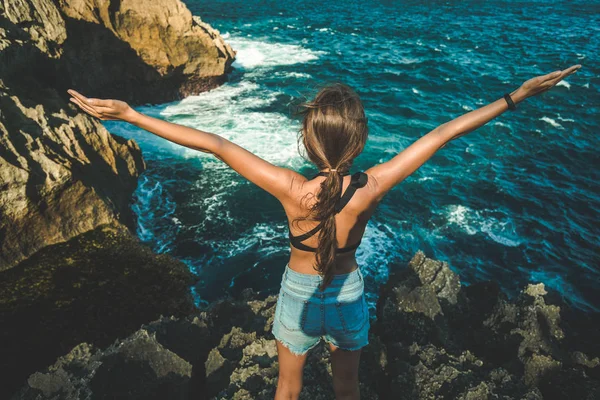 Young girl with arms raised up. Nusa Penida island — Stock Photo, Image