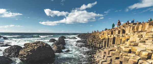 Toeristen op de keien strand. Noord-Ierland. — Stockfoto
