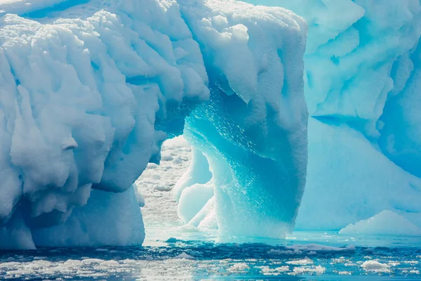 氷山のアーチをクローズ アップ 青と白の色合いで南極の風景です 氷の圧倒的なシーンには 北極海の中で浮かぶ氷河が覆われています 氷の山の幾何学的図形 ロイヤリティフリーのストック画像