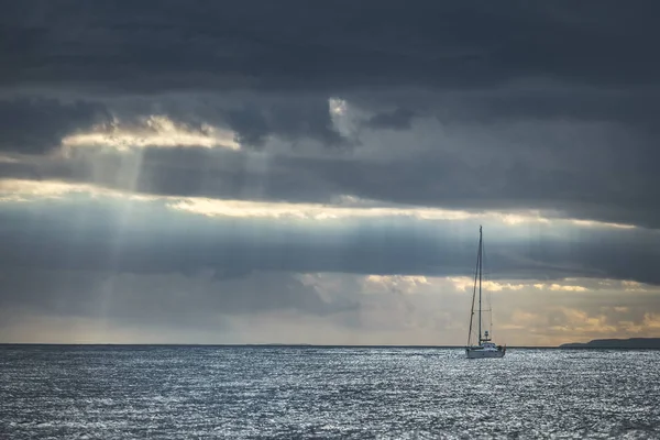 Regenachtige hemel boven de jacht in de zee. Ierland. — Stockfoto