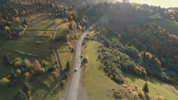 Auto rijdt langs grijze kronkelende asfalt heuvelachtige weg antenne — Stockvideo