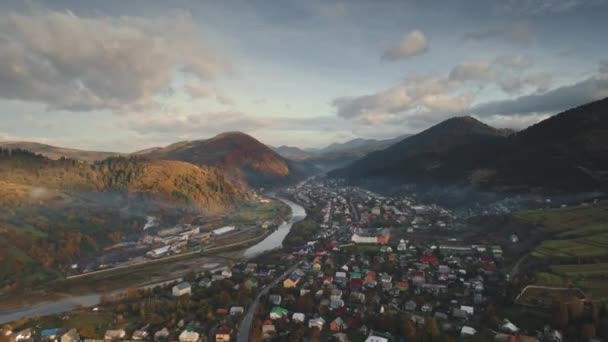 Casas de pueblo en sinuoso río de montaña y bosques verdes — Vídeo de stock