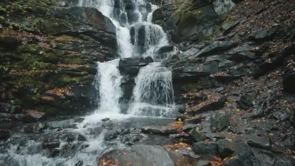 Großer Wasserfall auf grauem Felshügel gegen gelbe Bäume — Stockvideo