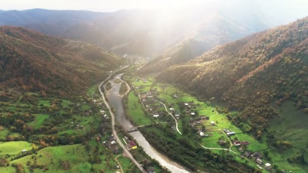 Río con puente conecta pueblos entre colinas forestales — Vídeo de stock