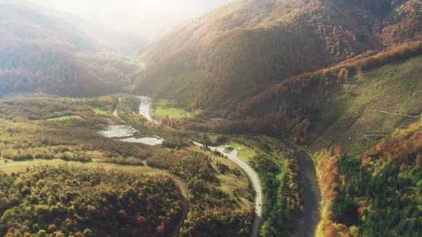 Серая асфальтовая дорога на голубой извилистой горной реке, освещенной солнцем — стоковое видео