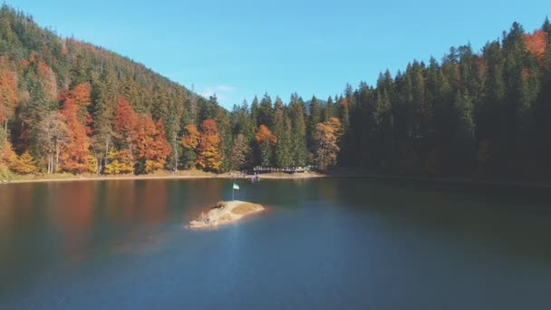 Lago tranquilo azul pictórico con bandera en la isla rocosa en el centro — Vídeos de Stock