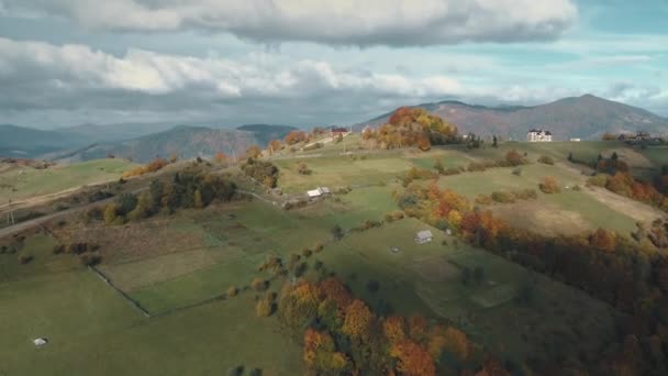 Прекрасные редкие дома, разбросанные по лугам зеленого холма — стоковое видео