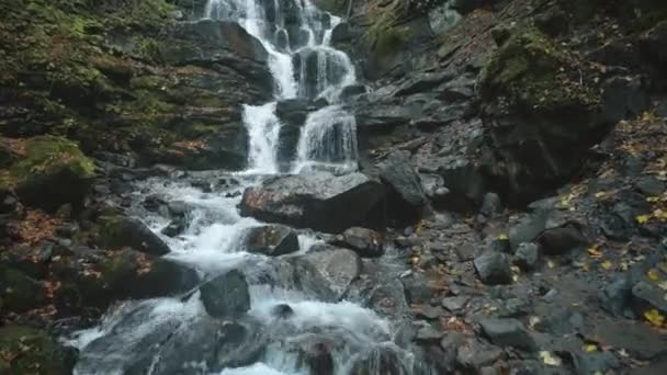 Pěnící voda z horských vodopádů obklopená mokrými kameny — Stock video