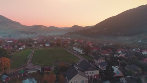 Прекрасный город с футбольным полем у подножия холма — стоковое видео