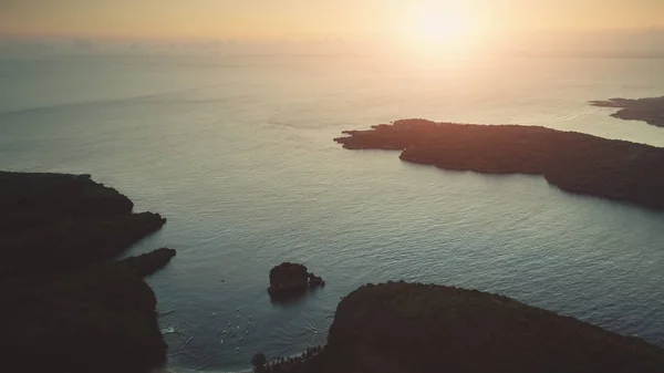 日落海洋野岛湾上空的空中飞行 — 图库照片