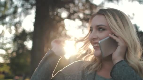 Mujer joven y feliz hablar en el teléfono móvil al aire libre — Vídeo de stock