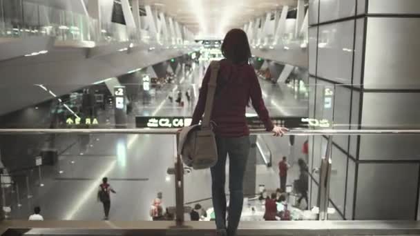 Vrouw passagier stand kijk op moderne luchthaven hal — Stockvideo