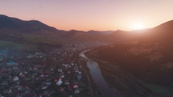 Pittoresk bergstadje aan brede rivieroever tegen heuvels — Stockvideo