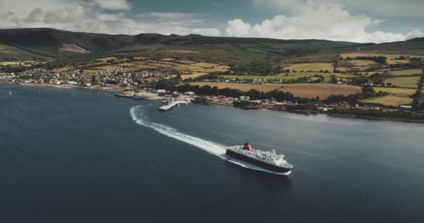 Terminal de ferries, vista aérea del Golfo de Brodick. Nave cerca de la costa con zonas verdes y montañas — Vídeos de Stock