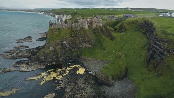 Irlande château médiéval de Dunluce vue aérienne sur la falaise dans le comté d'Antrim. Paysage vert pittoresque — Video
