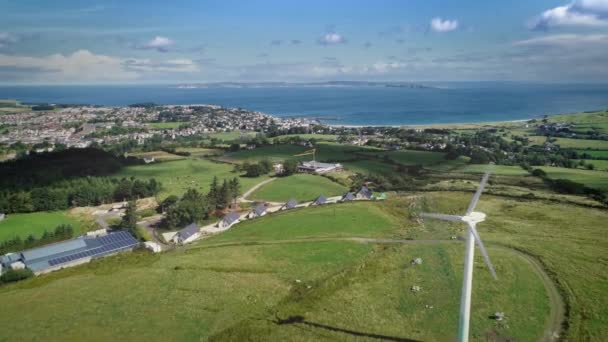 Irlanda cidade portuária moinho de vento vista aérea na baía do oceano Atlântico. Bela paisagem de prado verde — Vídeo de Stock