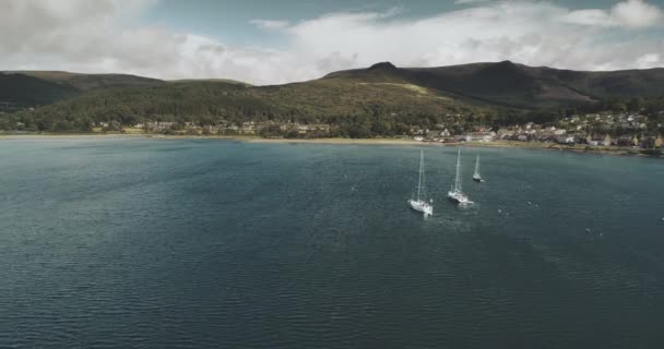 Ecosse Aérien : voiliers océaniques, vue sur les yachts dans les eaux côtières près du village de Brodick, île d'Arran. — Video