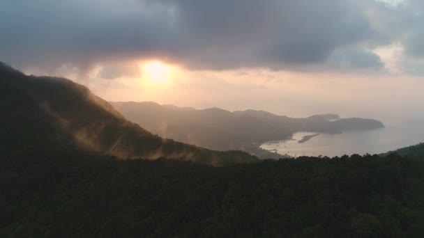 Закат, силуэт гор в воздухе: Таиланд увеличивает масштаб съемки. Лес в солнечных лучах света на облачном небе — стоковое видео
