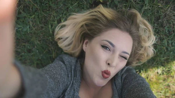 Glad ung kvinna skratta Lie på gräs närbild — Stockfoto