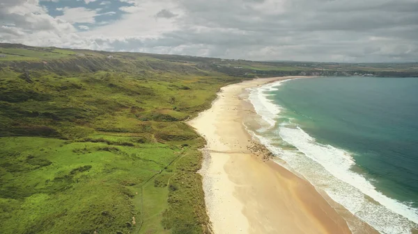 Plaża na wybrzeżu: Ocean Atlantycki, hrabstwo Antrim, Irlandia Północna. Ludzie chodzący po piaszczystym brzegu — Zdjęcie stockowe