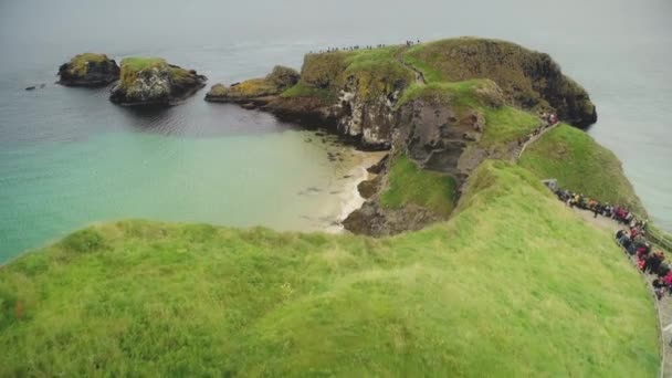Irish ocean aerial view: tourists walk on rope bridge, Carrick Island, Northern Ireland — Stock Video