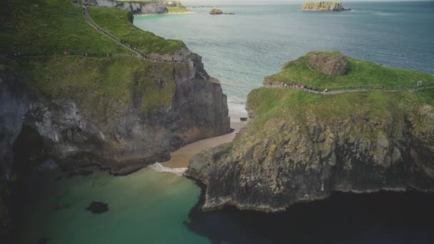 Carrick-a-Rede légi felvétel: Ír kötélhíd a tengerpart előtt. Festői látványosság — Stock videók