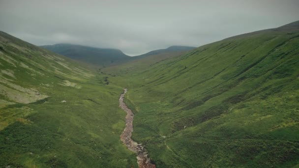 Cordilheira verde da Escócia. Caminho rochoso estreito ao longo da encosta ao pico nublado — Vídeo de Stock