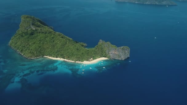 Vista aerea dell'isola tropicale dall'alto verso il basso nella baia oceanica. Barca, nave in acqua costiera. Foresta asiatica sull'isola collinare — Video Stock