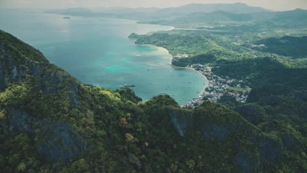 Ilha tropical montanhosa aérea: cidade cais paisagem urbana com navios, barcos na água. Floresta verde — Vídeo de Stock