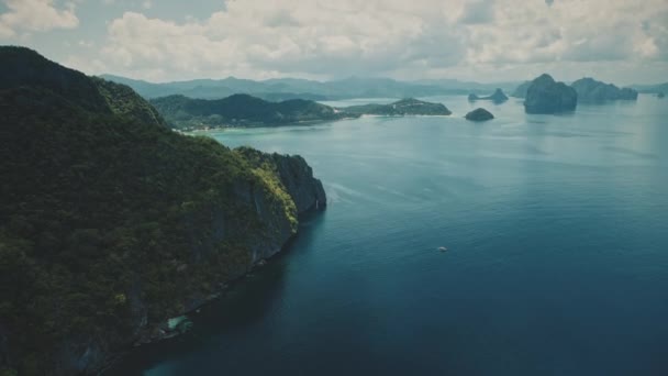 Горный остров в заливе океана вид с воздуха. Лазурный морской пейзаж. Зеленый тропический лес на берегу скалы — стоковое видео