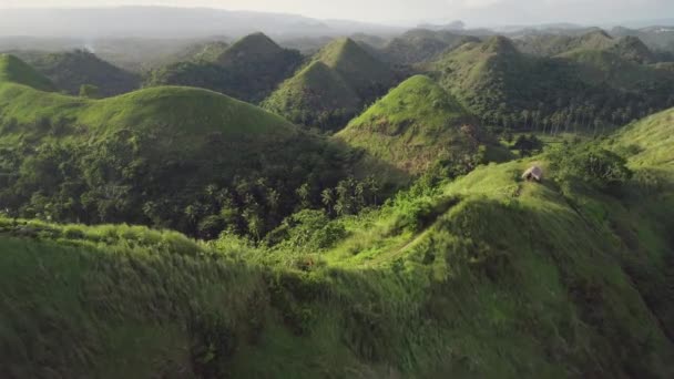 Timelapse green grass hills aerial: building, path at mounts ranges. Filipino nobody nature scape — Stock Video