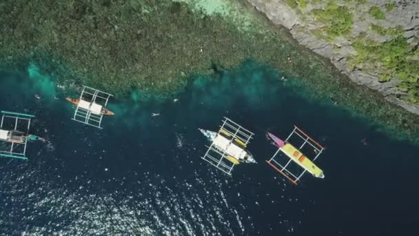 Верхній повітряний вид човнів на скелястому березі океану, піщаний пляж на узбережжі. Тропічний острів. — стокове відео