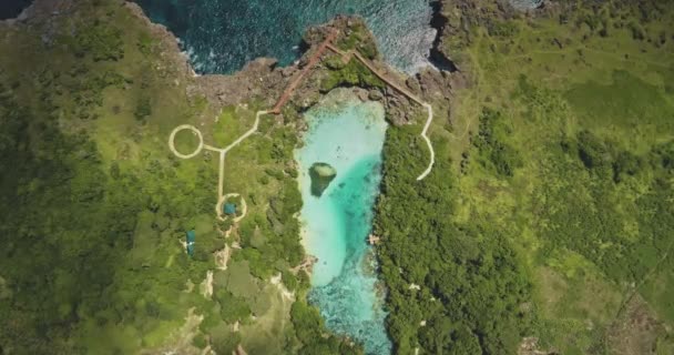 Topo para baixo do caminho do projeto no lago azul na vista aérea verde da costa do mar do penhasco. Prado tropical verde — Vídeo de Stock