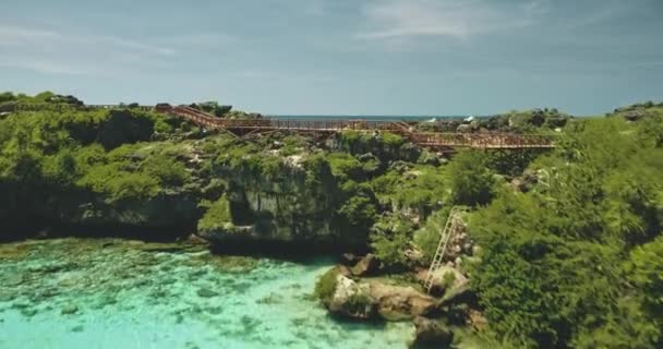 Yeşil uçurum okyanus kıyısındaki Limpid Gölü 'ndeki köprünün yakın görüntüsü. Destansı Endonezya manzarası — Stok video
