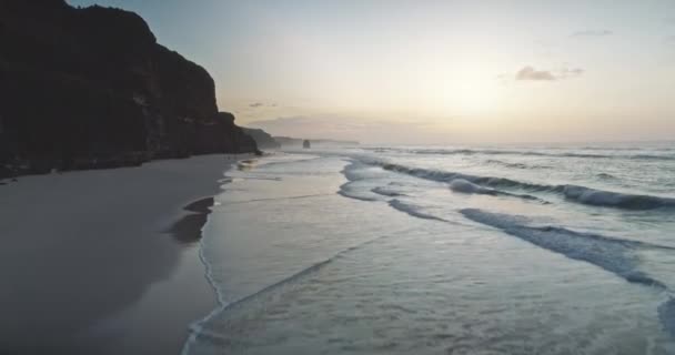 Langzame zonsopgang bij golvende oceaanklif kust vanuit de lucht. Zon opkomen bij donker rots, zee baai water — Stockvideo